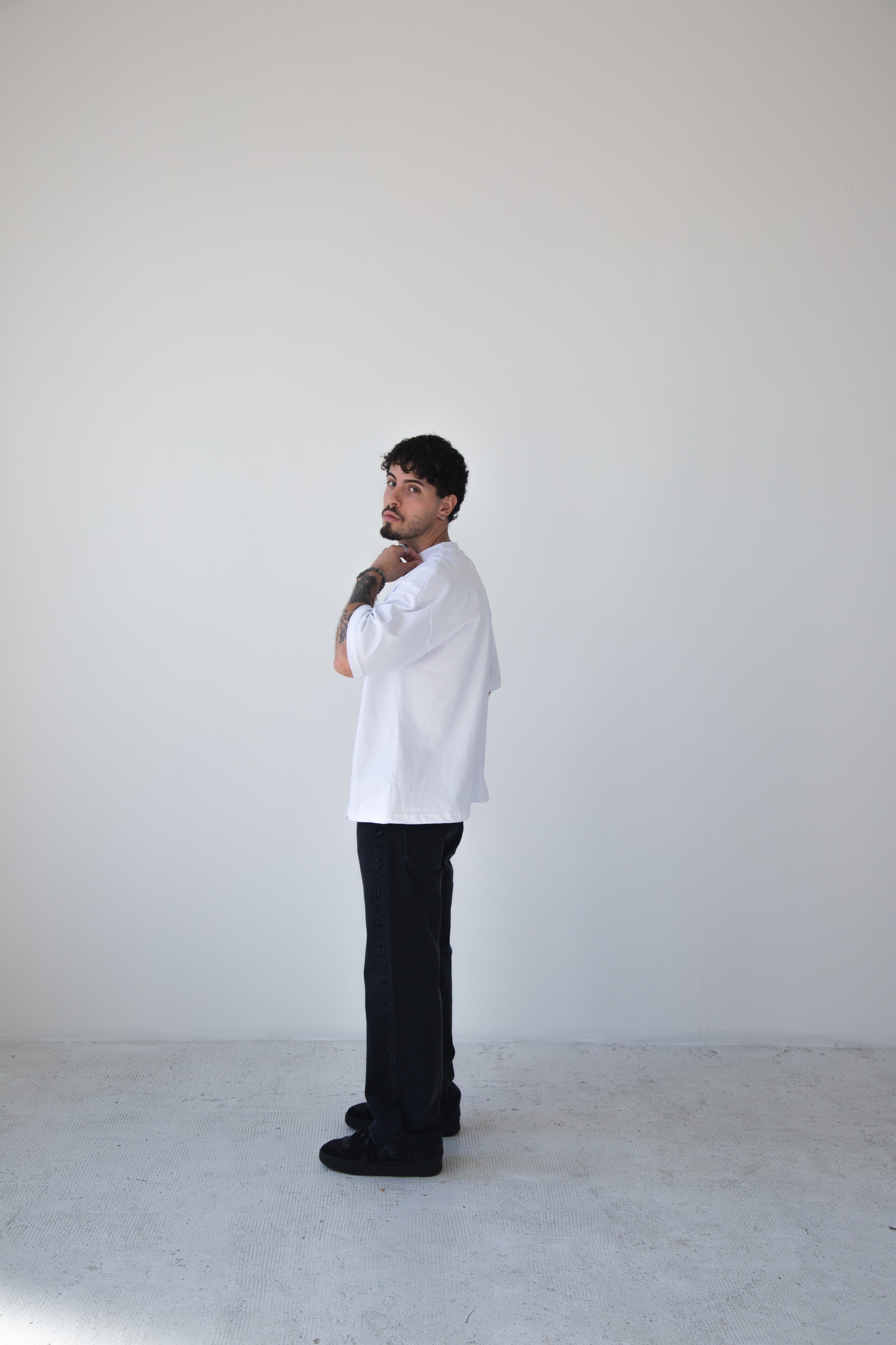 Bruno Esposto en estudio, remera blanca oversize y jean negro